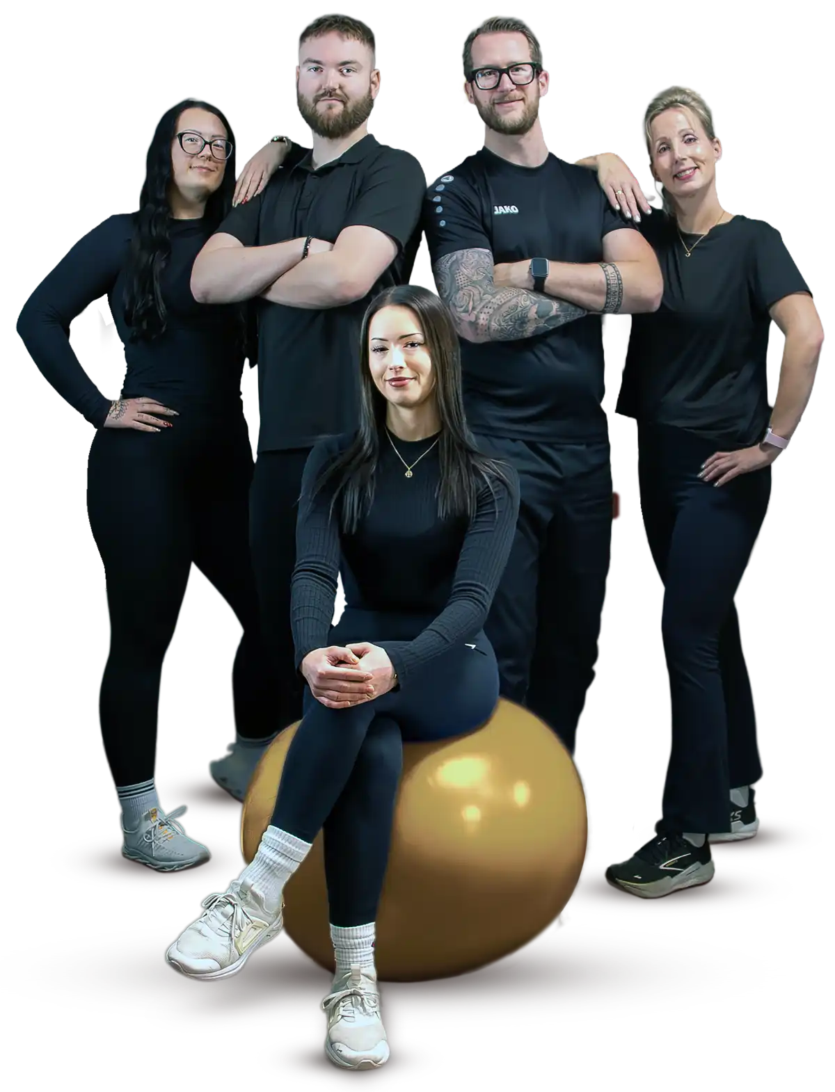 Das fünfköpfige Trainer-Team von SOMT!X in Waren (Müritz) posiert selbstbewusst in schwarzer Sportkleidung. Eine Trainerin sitzt im Vordergrund auf einem goldenen Gymnastikball.